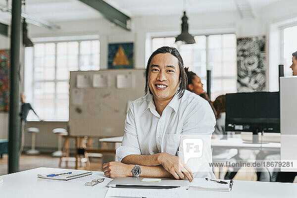 Portrait of smiling businessman at modern work place