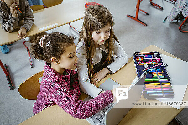 Hohe Winkel Ansicht der Schülerinnen mit Laptop zusammen am Schreibtisch im Klassenzimmer