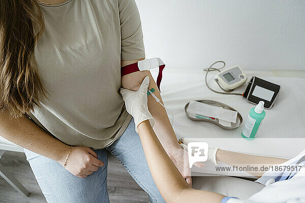 Hohe Winkel Ansicht des Arztes Entfernen von Blut aus dem Arm des Patienten in der Klinik