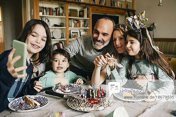 Junge nimmt Selfie mit Familie essen Geburtstagskuchen während genießen zu Hause