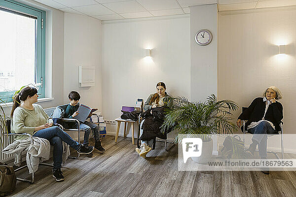 Patients sitting on chair while waiting in clinic