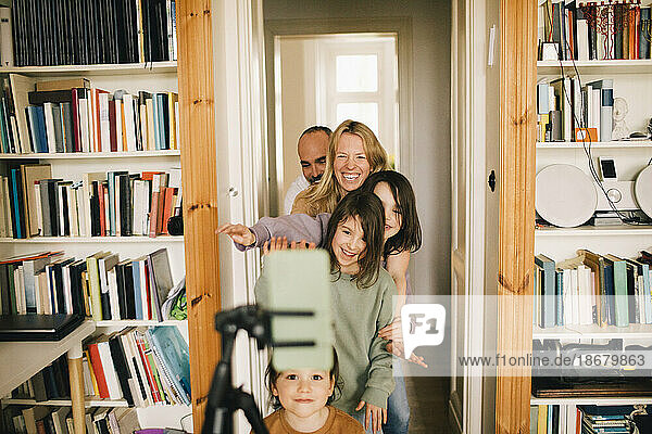 Glückliche Familie  die zu Hause mit dem Smartphone filmt