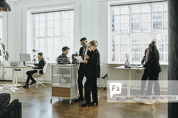 Male and female business colleagues working together at corporate office