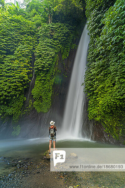 View of woman taking picture at Melanting waterfall  Kabupaten Buleleng  Gobleg  Bali  Indonesia  South East Asia  Asia