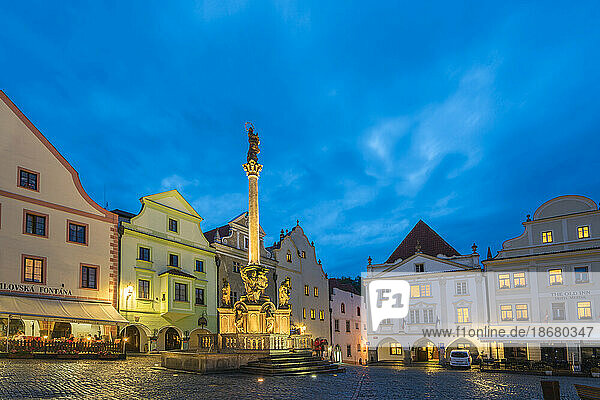 Fountain and Plague Column with traditional houses with gables in background at twilight  Namesti Svornosti Square in historical center  UNESCO World Heritage Site  Cesky Krumlov  Czech Republic (Czechia)  Europe