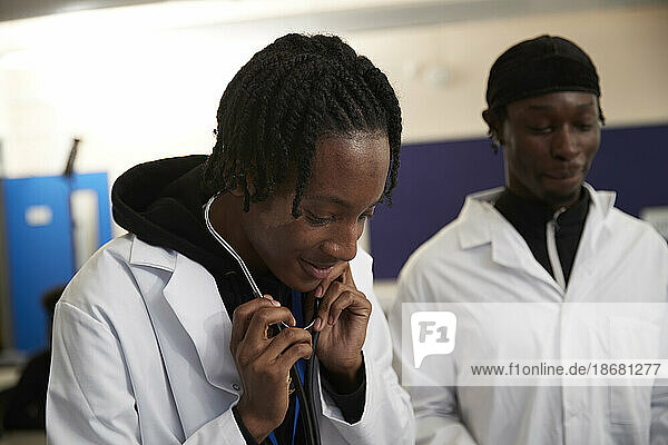 Medical student using stethoscope in class