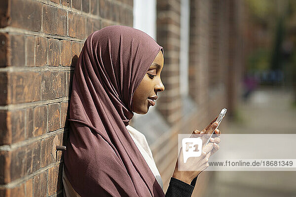 Young woman in hijab using phone