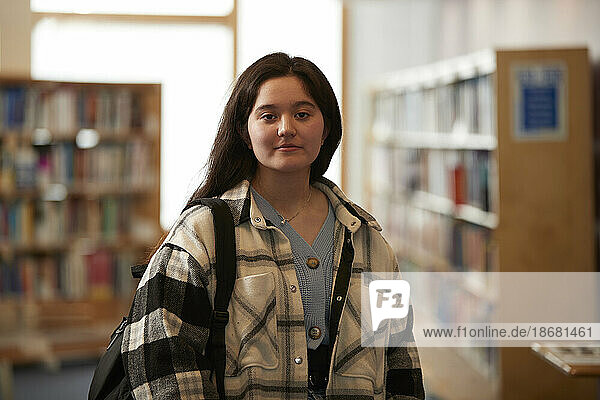 Portrait of female student (16-17) in library