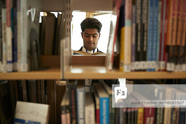 University student reading books in library
