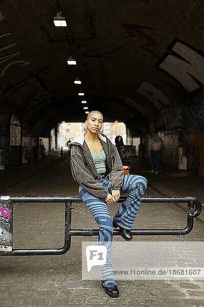Portrait of hipster young woman sitting in tunnel
