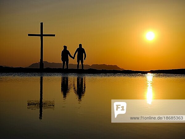 Couple next to summit cross at sunset  silhouette  reflection in the water  Trattberg  Bad Vigaun  Land Salzburg  Austria  Europe