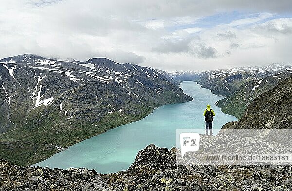 Bergsteiger blickt in die Ferne  Besseggen Wanderung  Gratwanderung  Ausblick auf See Gjende und Berge  Jotunheimen Nationalpark  Vågå  Innlandet  Norwegen  Europa