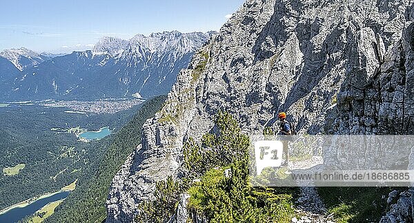 Bergsteiger beim Aufstieg zur Oberen Wettersteinspitze  hinten Lautersee und Karwendelgebirge mit Westlicher Karwendelspitze  Wettersteingebirge  Bayerische Alpen  Bayern  Deutschland  Europa