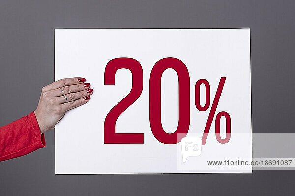 Weibliche Hand hält ein 20% Plakat. Studioaufnahme. Werbekonzept