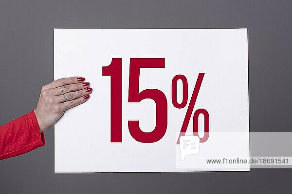 Weibliche Hand hält ein 15% Plakat. Studioaufnahme. Werbekonzept