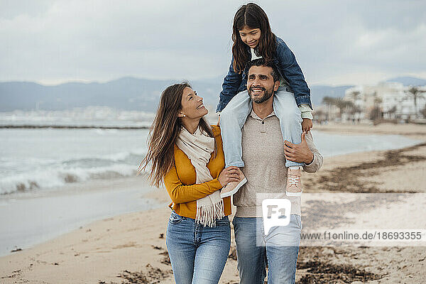 Glückliche Familie  die gemeinsam an der Küste am Strand spaziert