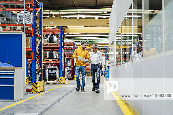 Mature businessmen having discussion and walking in factory