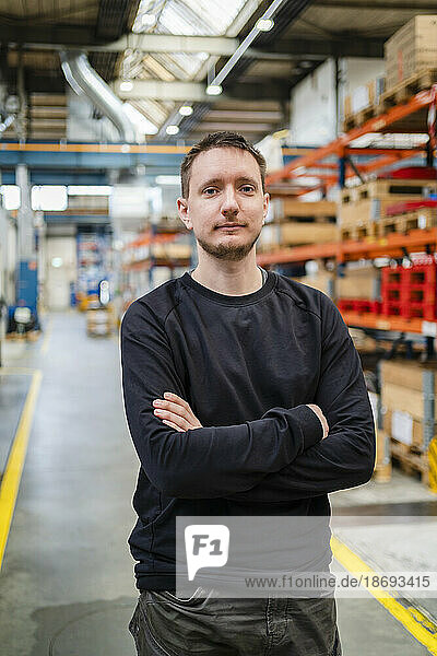 Young employee with arms crossed in industry