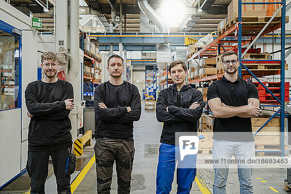 Employees with arms crossed standing in factory