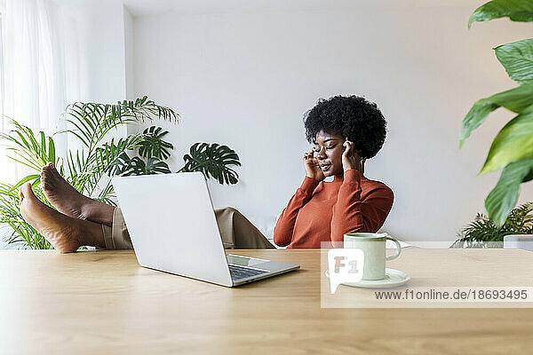Nachdenkliche Geschäftsfrau sitzt mit geschlossenen Augen am Schreibtisch