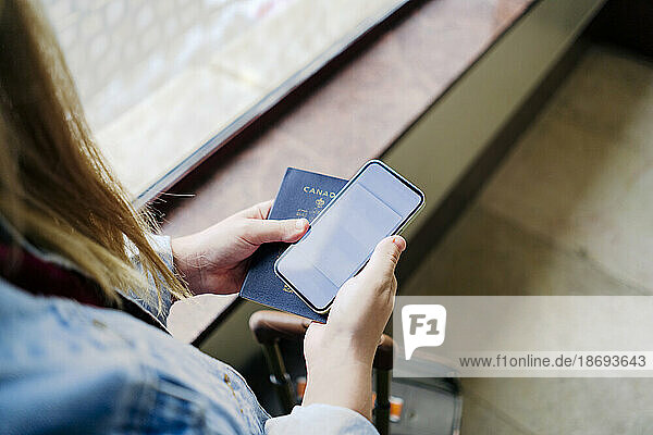 Woman holding smart phone and passport