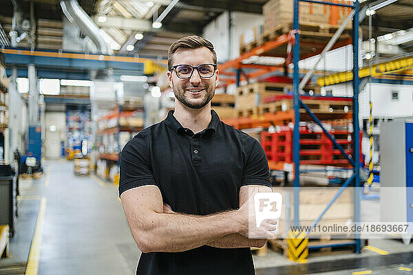 Smiling employee wearing eyeglasses at factory
