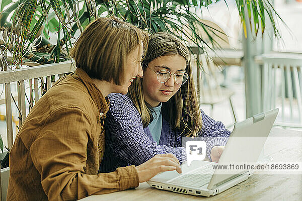 Mutter und Tochter benutzen Laptop im Café