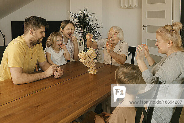 Multi-generation family having fun playing game at home