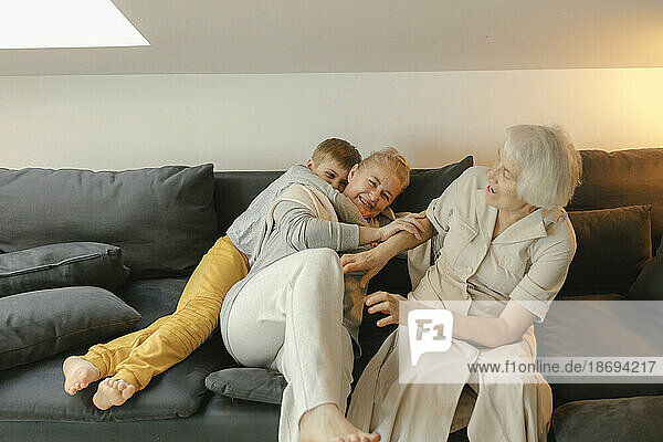 Glückliche Familie genießt es  zu Hause auf dem Sofa zu sitzen