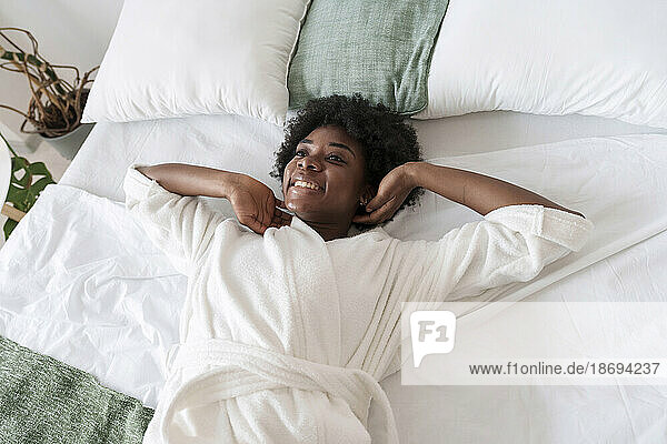 Happy woman taking rest on bed at home