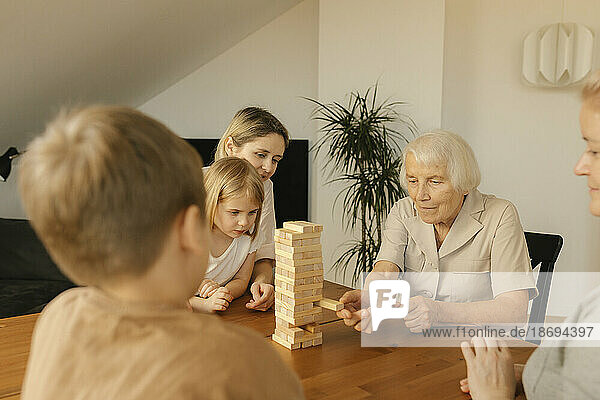 Elderly woman playing game with family at home