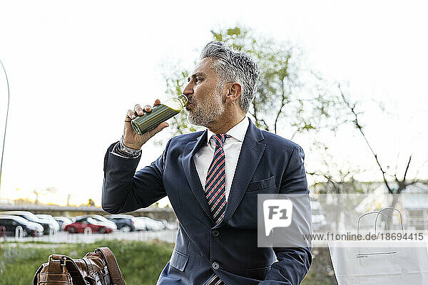 Mature businessman drinking detox smoothie