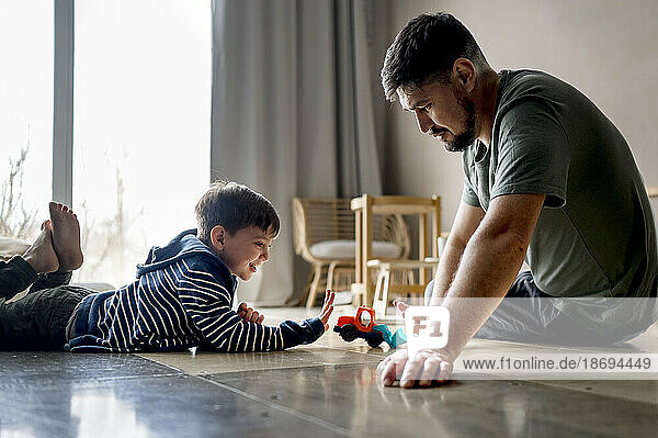 Father and son playing with toy at home