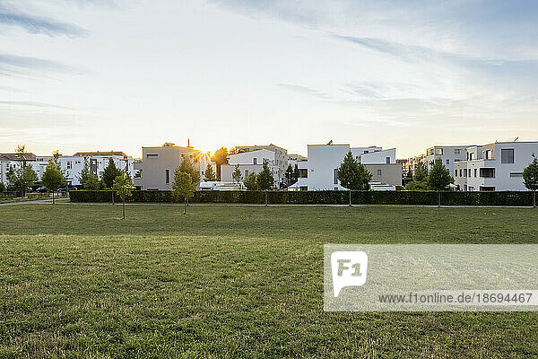 Germany  Bavaria  Augsburg  Grassy area in front of new modern suburban flats at sunset