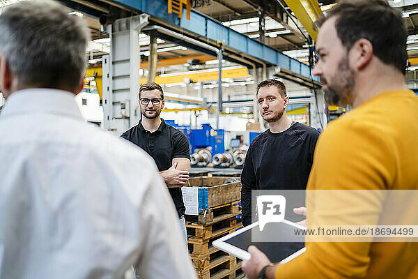 Business colleagues conducting meeting in factory