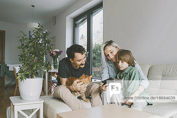 Happy family with cats looking at camera