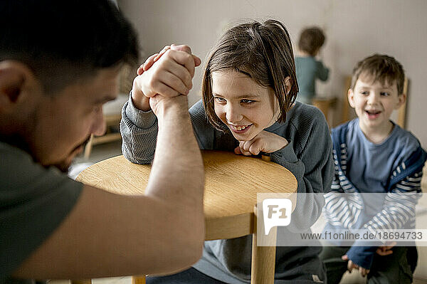 Father arm wrestling with son at home