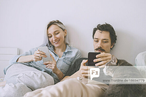 Happy couple using smart phone at home