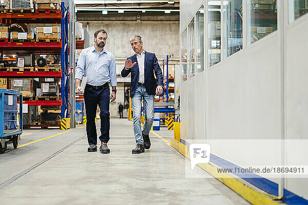 Businessman and manager walking together at factory