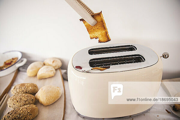 Kochzange  die Brottoast vom Toaster entfernt