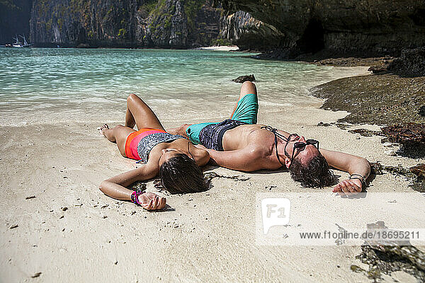 Carefree couple lying on sand at beach