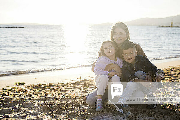 Woman spending leisure time with son and daughter at beach