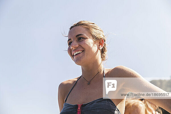 Happy young woman wearing swimwear under clear sky