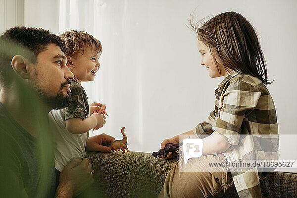 Father spending leisure time with sons playing at home
