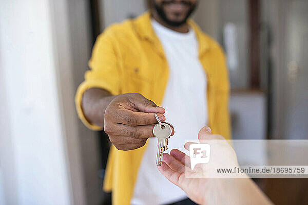 Real estate agent giving house keys to man