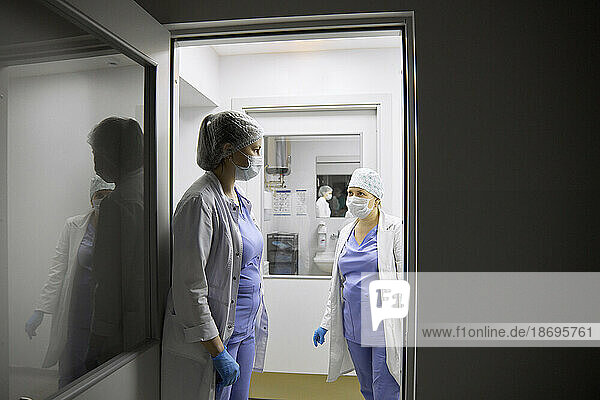 Surgeons discussing at entrance of operating room