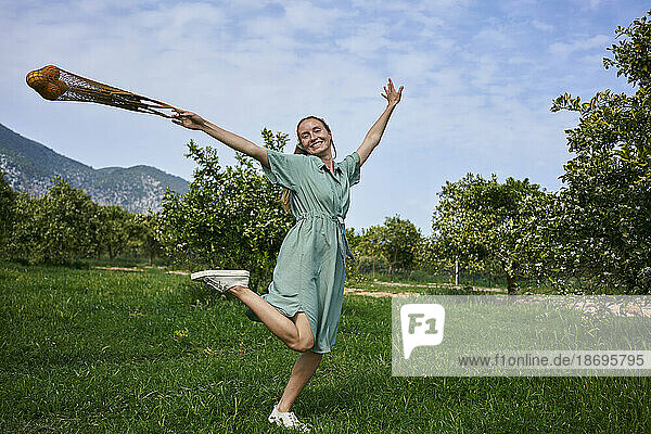 Carefree woman enjoying on grass in orange orchard