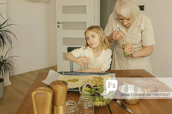 Großmutter bereitet mit Enkelin zu Hause Essen zu