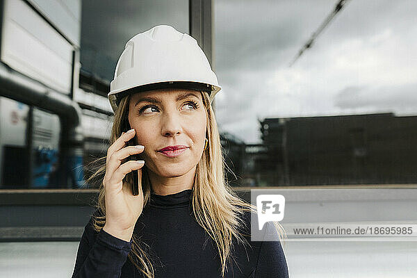 Contemplative businesswoman talking on smart phone