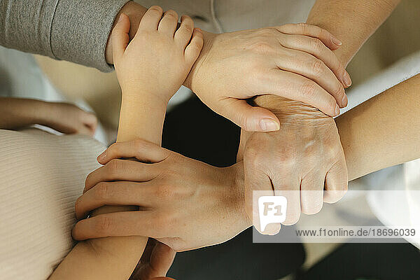 Family holding hands of each other at home